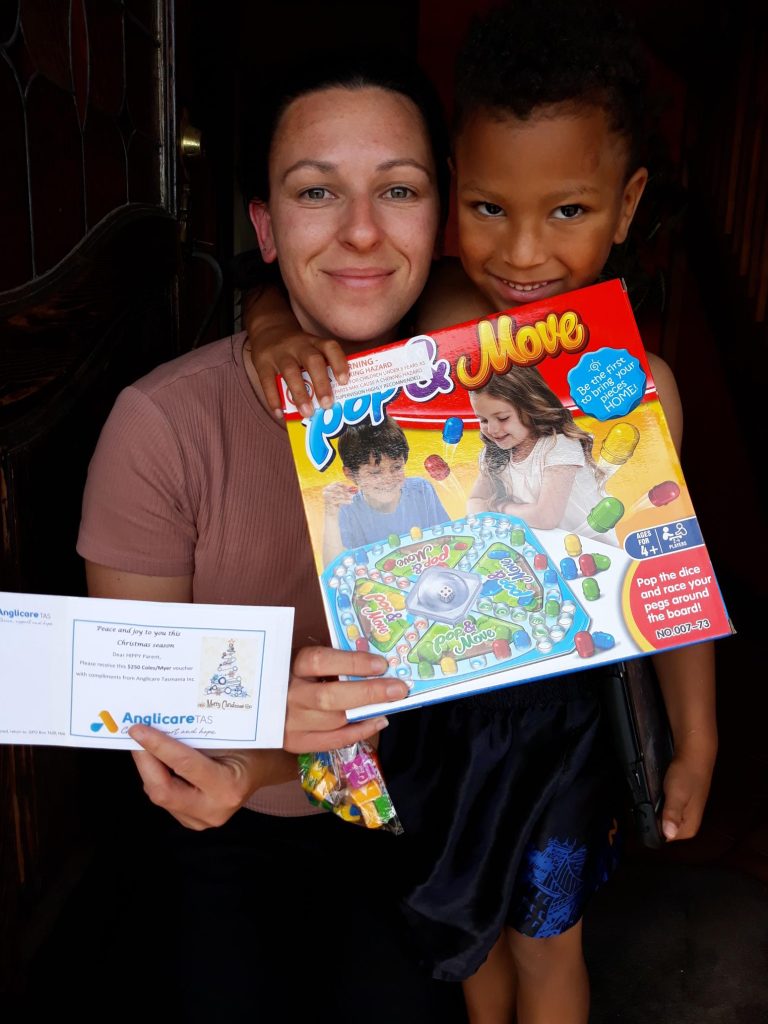 Photo of a parent with their child and a game they recieved for christmas